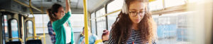 A young girl on a bus with headphones on.