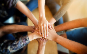 A group of people with their hands stacked upon one another.