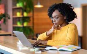 A young woman reading her laptop.