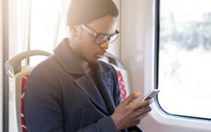 A man on the bus reading his phone.