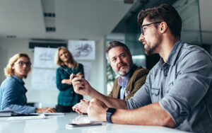 A group of people at a meeting talking to one another.