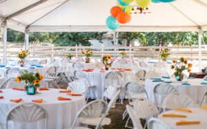 An outdoor event space with balloons and tables set