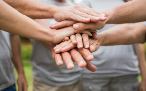 A group of people with their hands stacked upon one another.