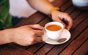 A person holding a cup of tea.