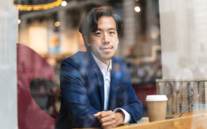 A man sitting in a cafe behind glass.